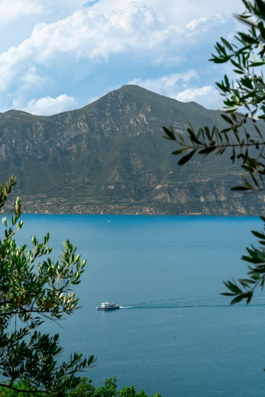 the boat is traveling through the water near a mountain range