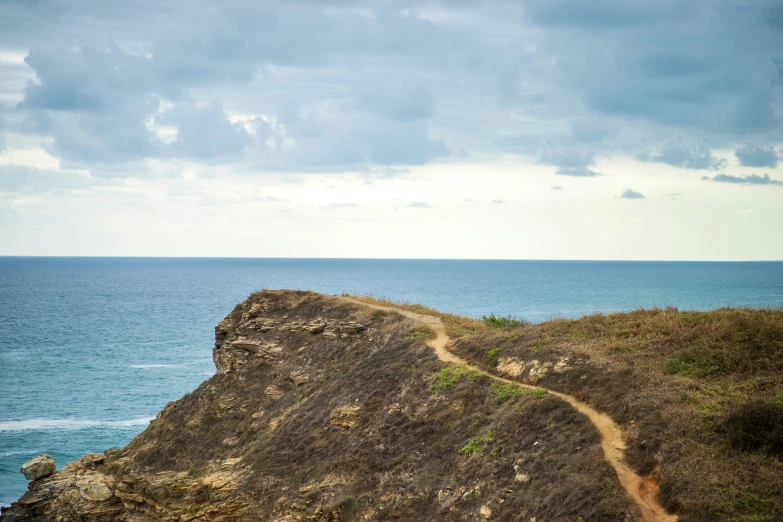 a small dirt path crosses over the cliff