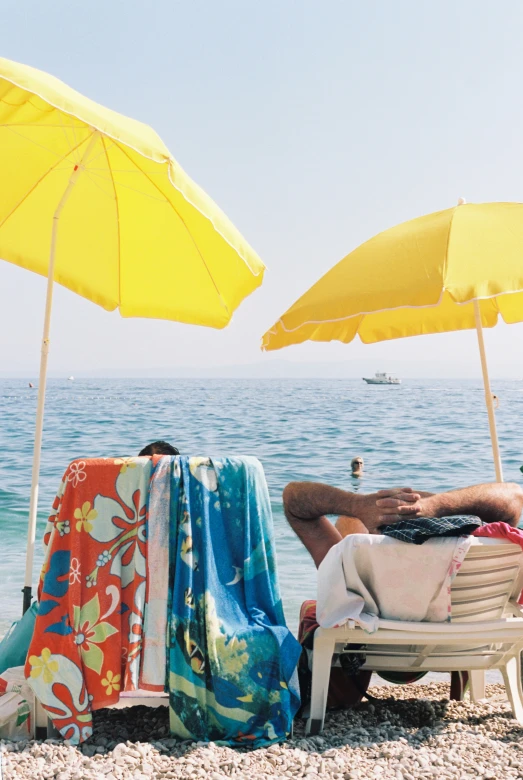 people relaxing at the beach on the sand