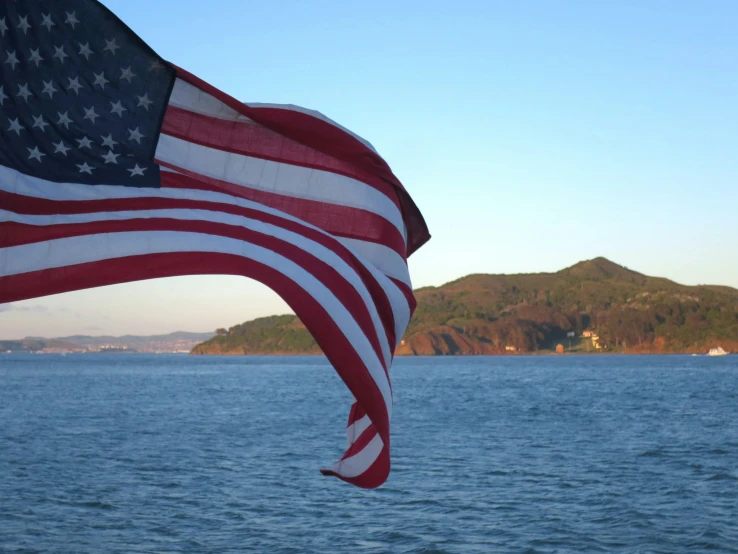 there is an american flag blowing in the wind on a boat