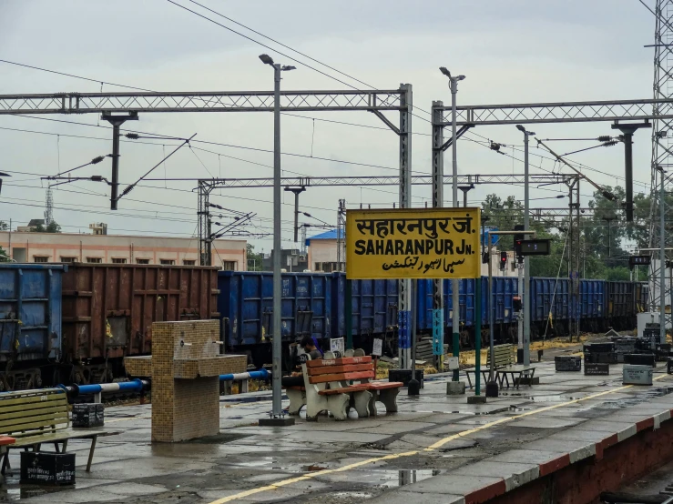 several chairs and tables are beside the railroad tracks