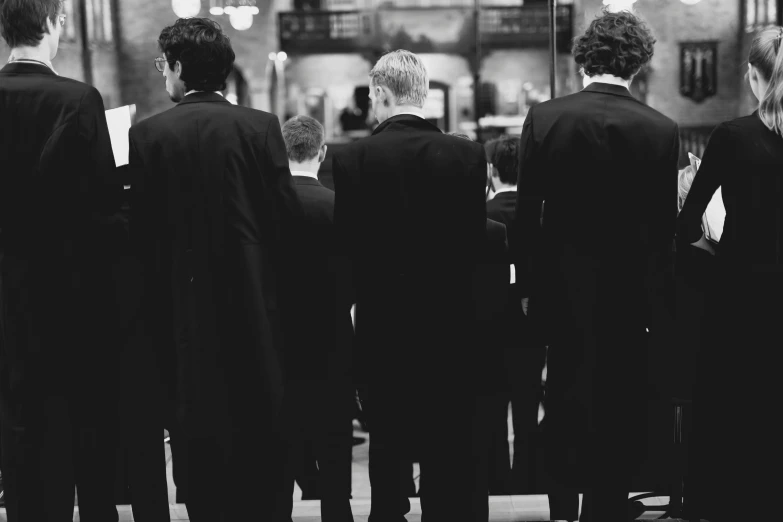 a group of men in suits and ties stand at the end of a tunnel