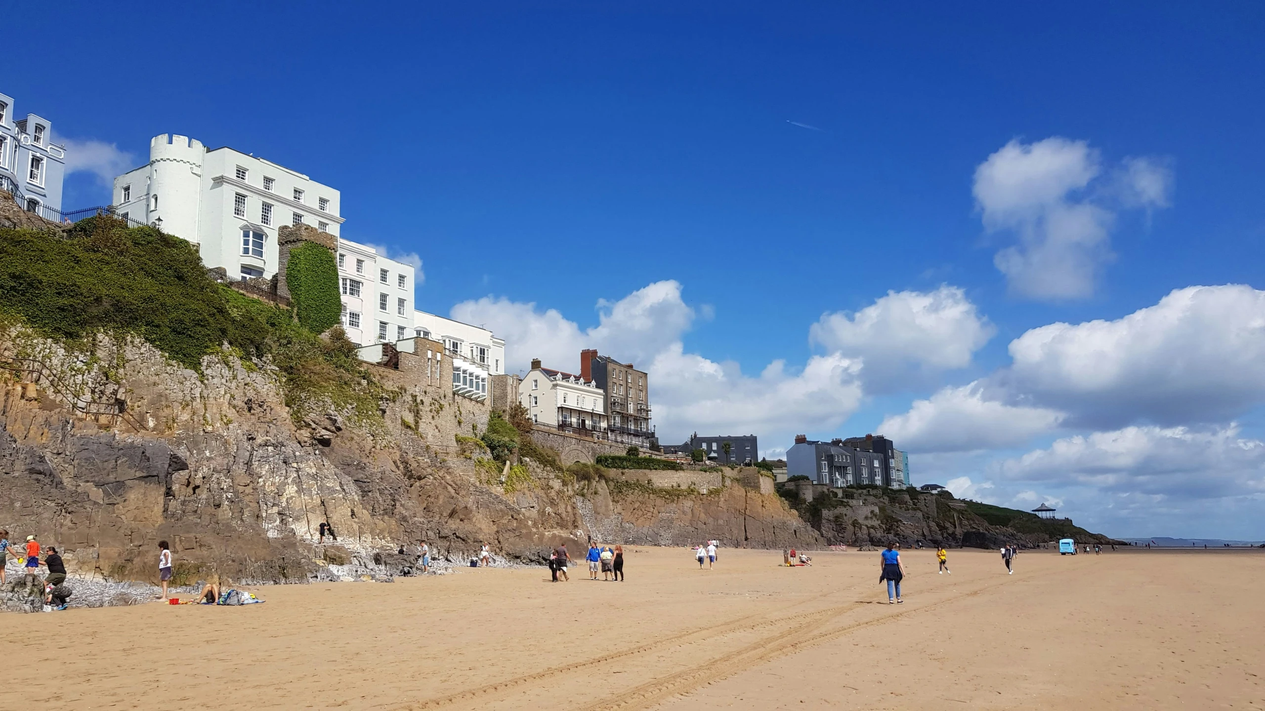 people are on the beach in the distance