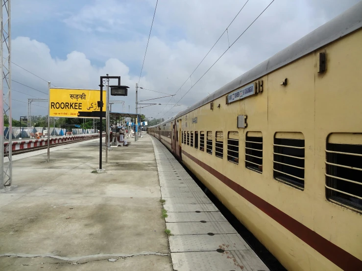 a long yellow passenger train on a track