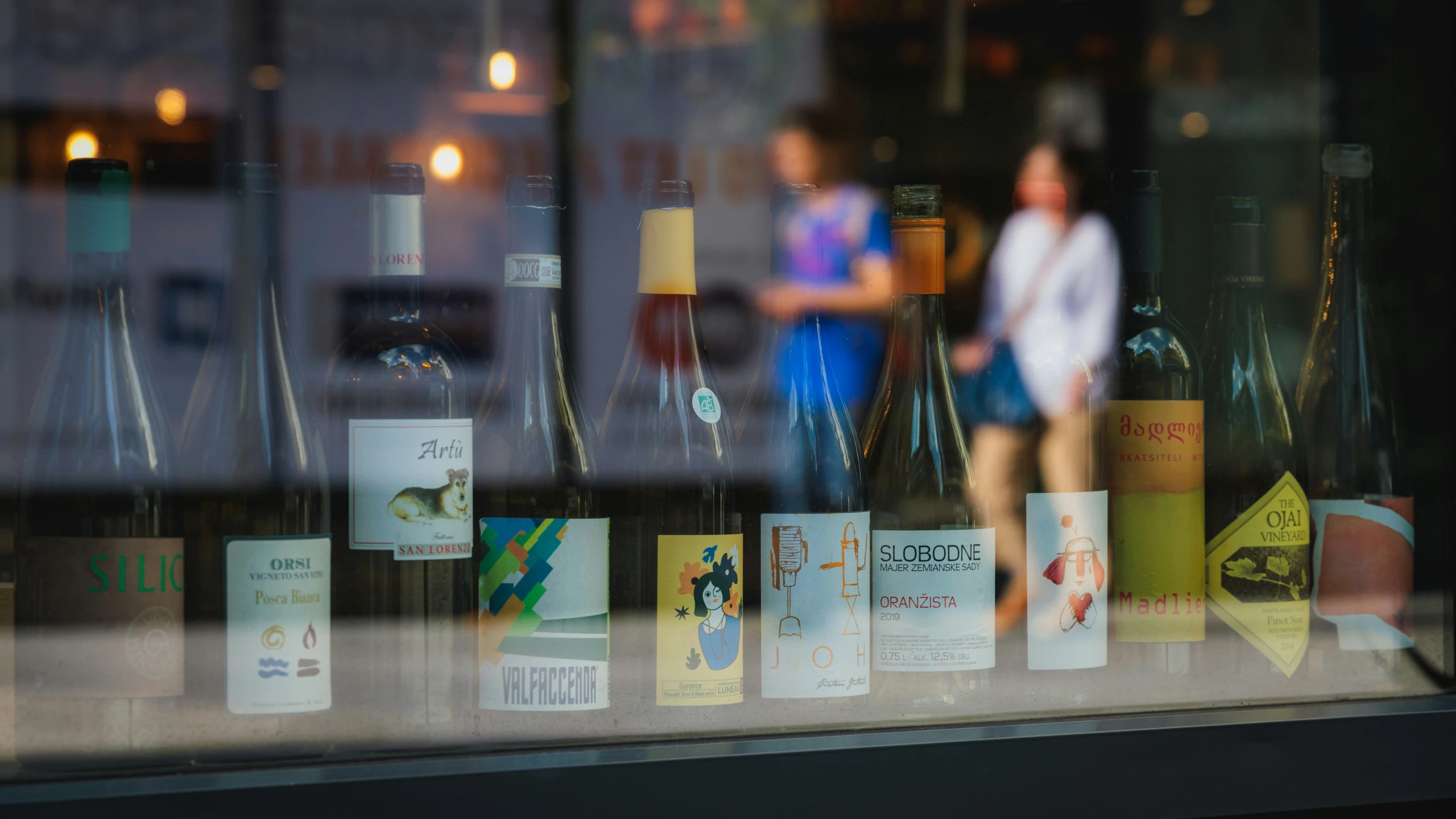 a woman standing outside of a wine shop