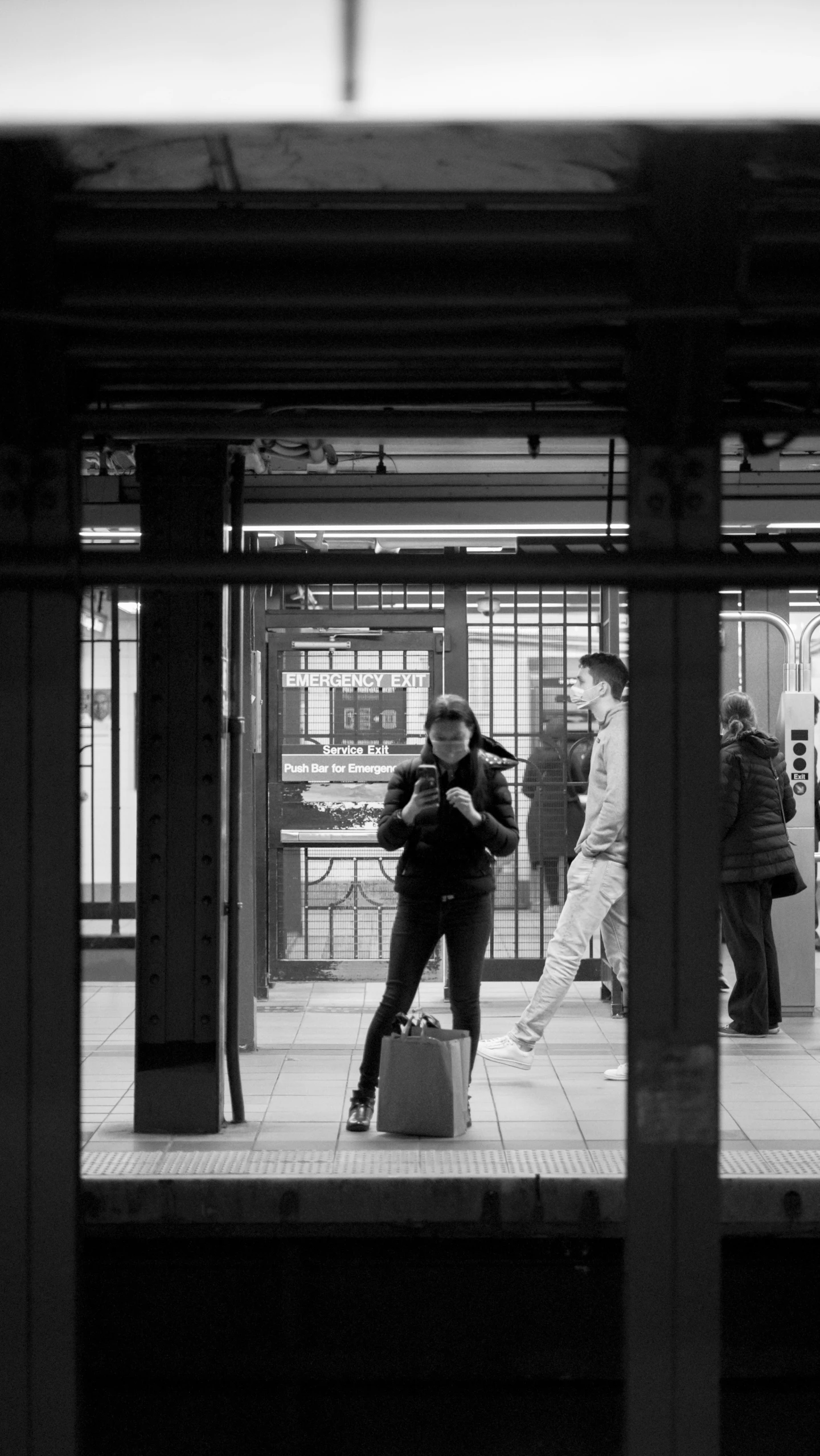 black and white po of three people standing on subway platform