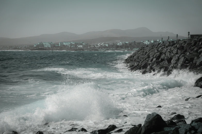 the view of a beach from a rocky shoreline