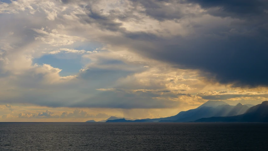 clouds gather over mountains in the distance