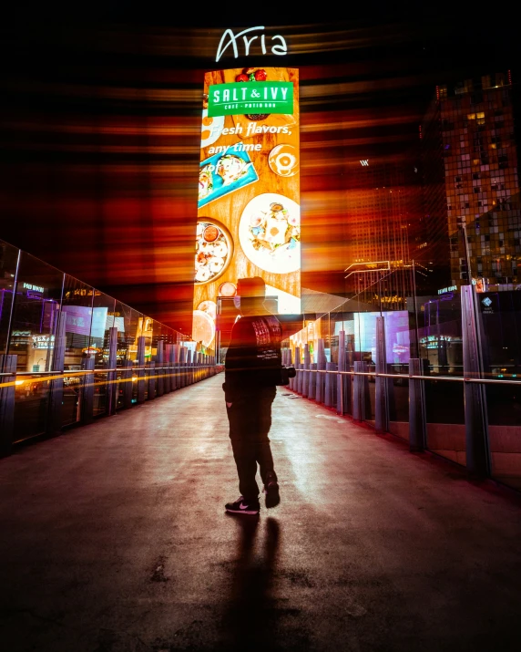 a person walks in front of neon signs in the background