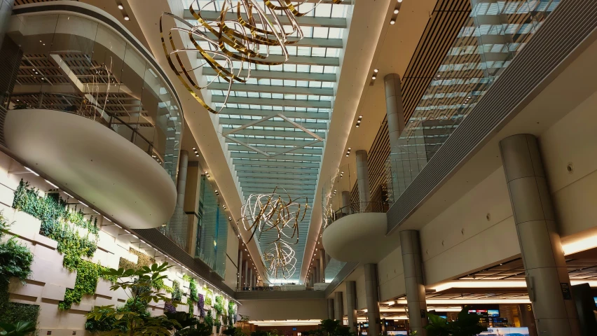 a lobby with multiple plants hanging from the ceiling