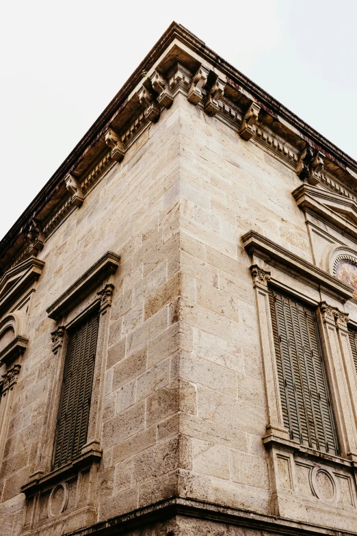 a tall tan building with many windows on top