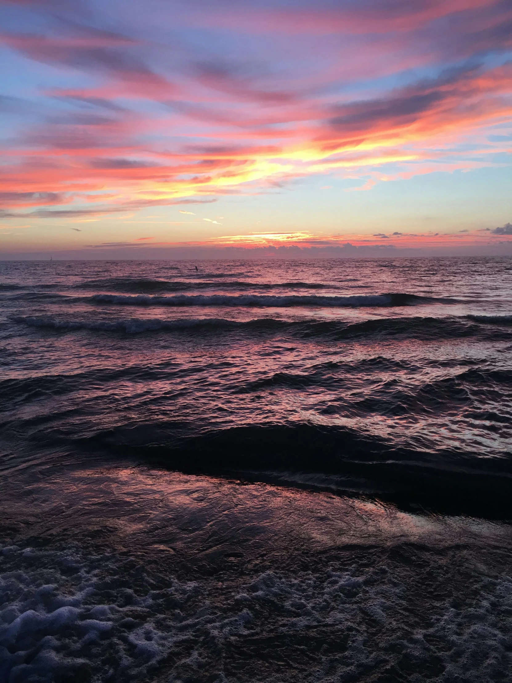 ocean waves against a sunset sky on the beach