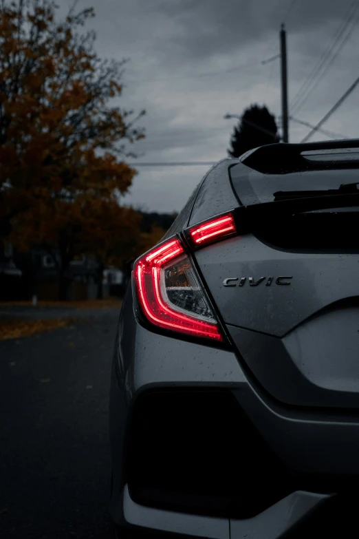 the tail light of an automobile parked at night