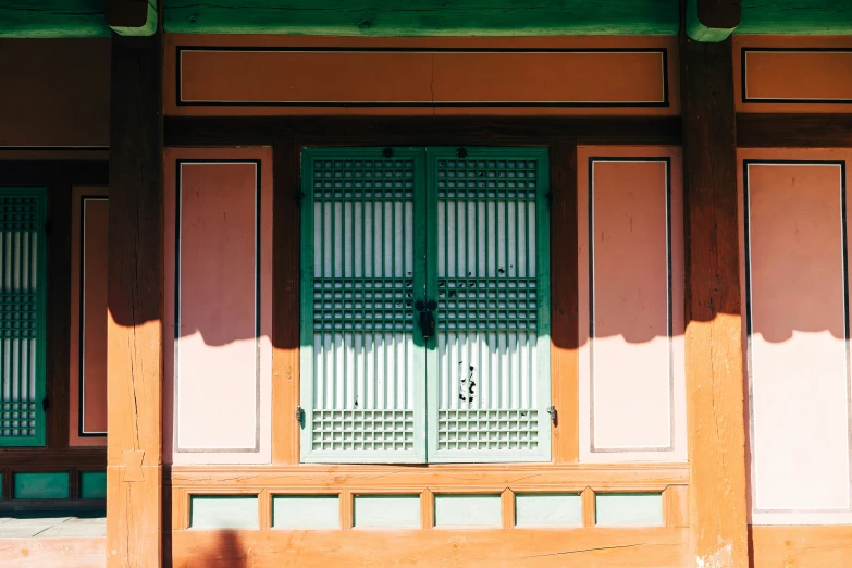 green double doors in a building with brown columns
