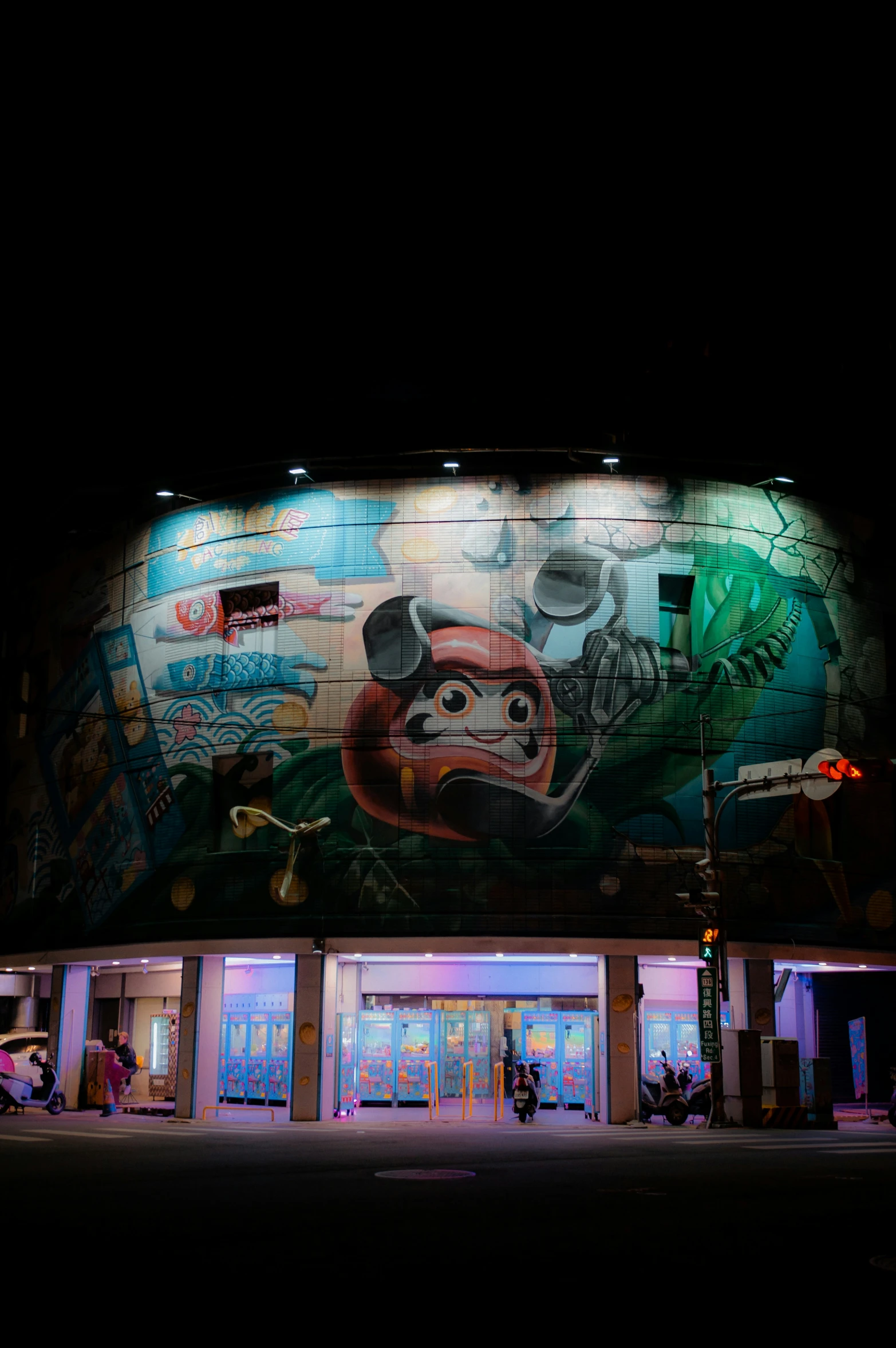 brightly lit building with graffiti on the side at night