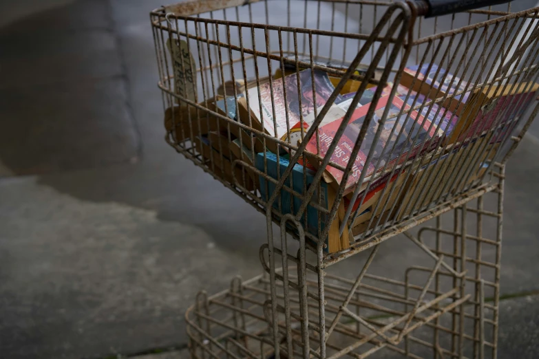 a shopping cart filled with magazines on the street