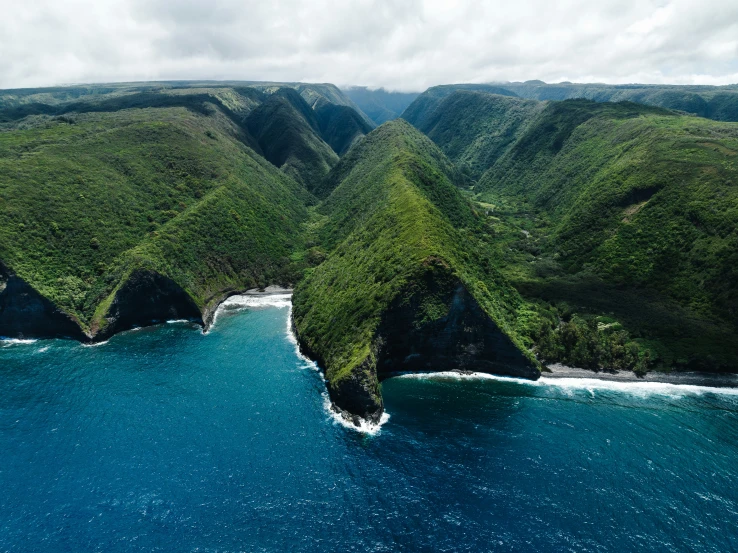 an aerial view of the ocean near an island in the middle of the ocean