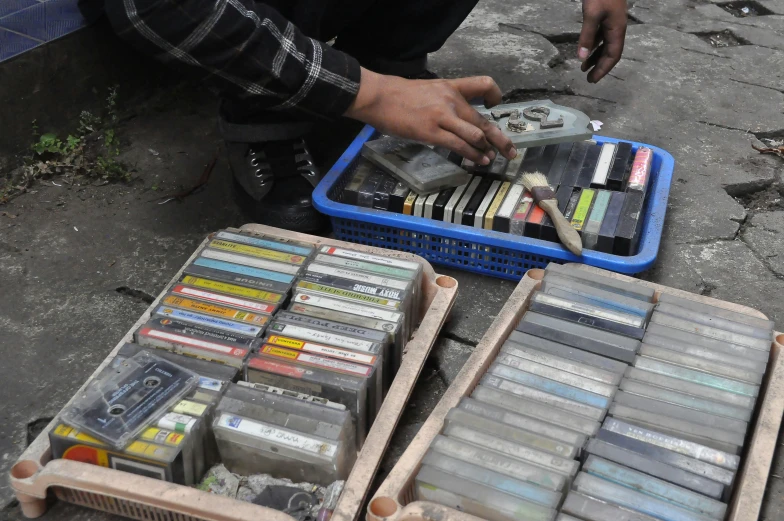 a man sits down next to boxes of crayons