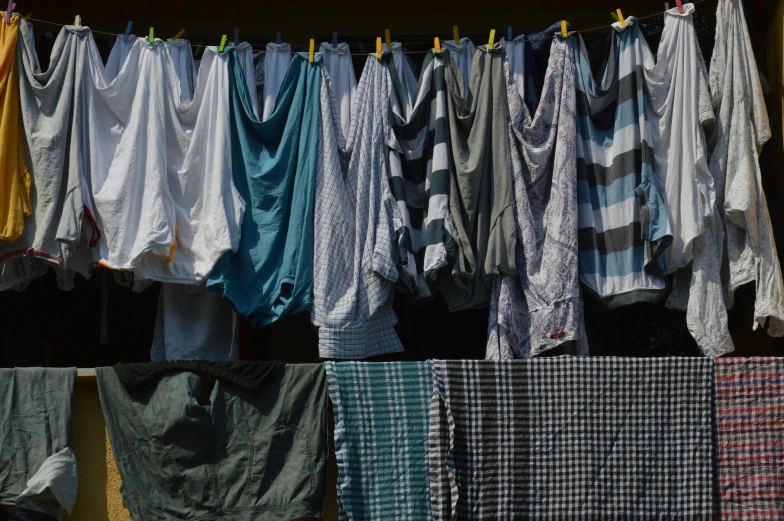 many different colors and patterns of clothes hanging outside