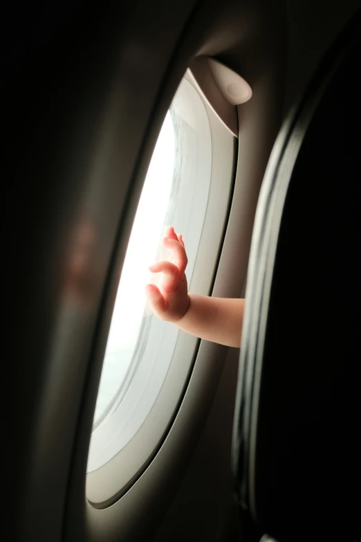 a hand on the windows of an airplane