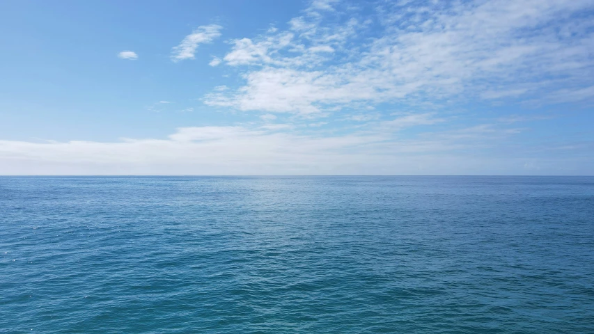 a large body of water sitting under a blue sky