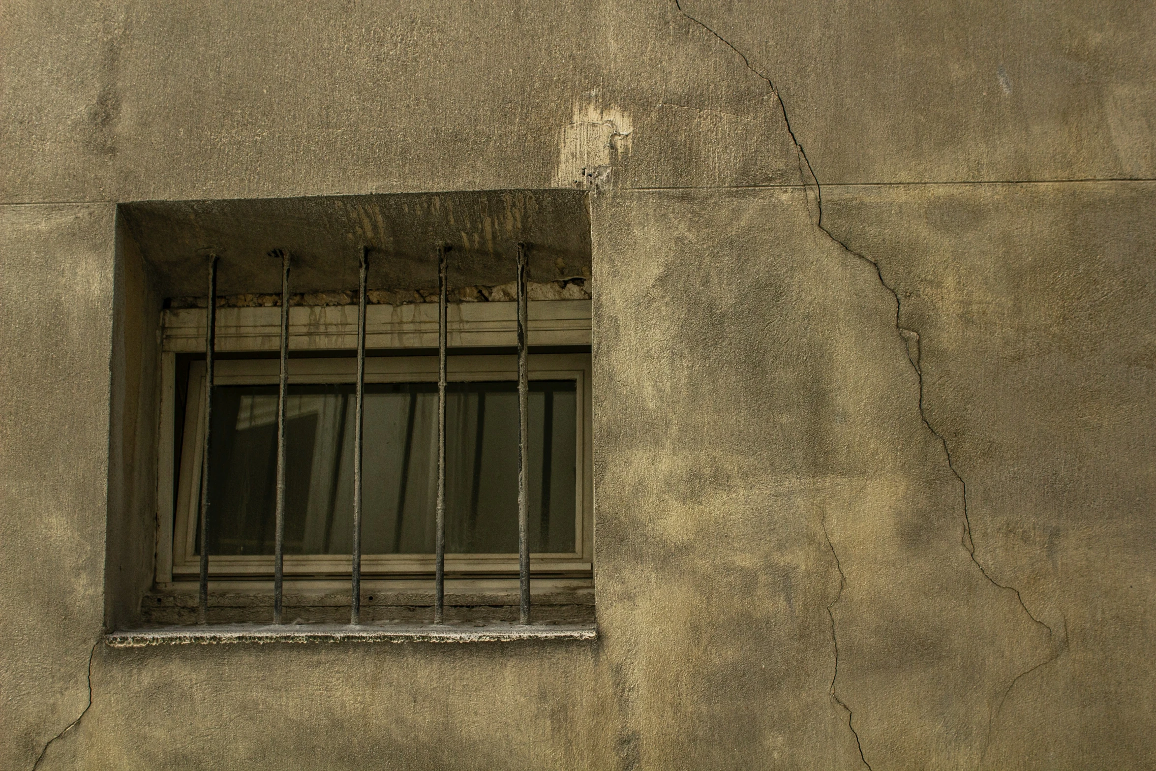 a window on a concrete wall with bars