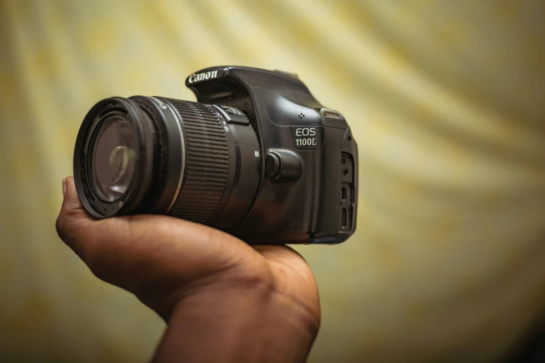 a hand holding a camera with the lens up to it