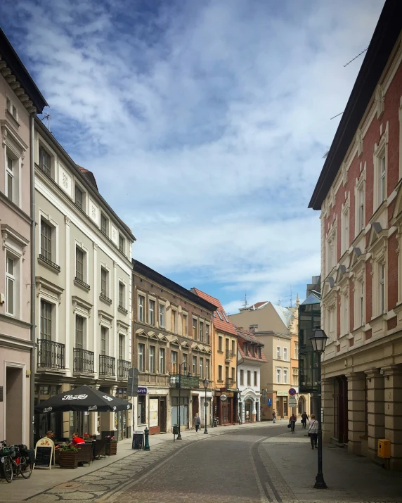 a group of buildings on street next to sidewalk with a couple people