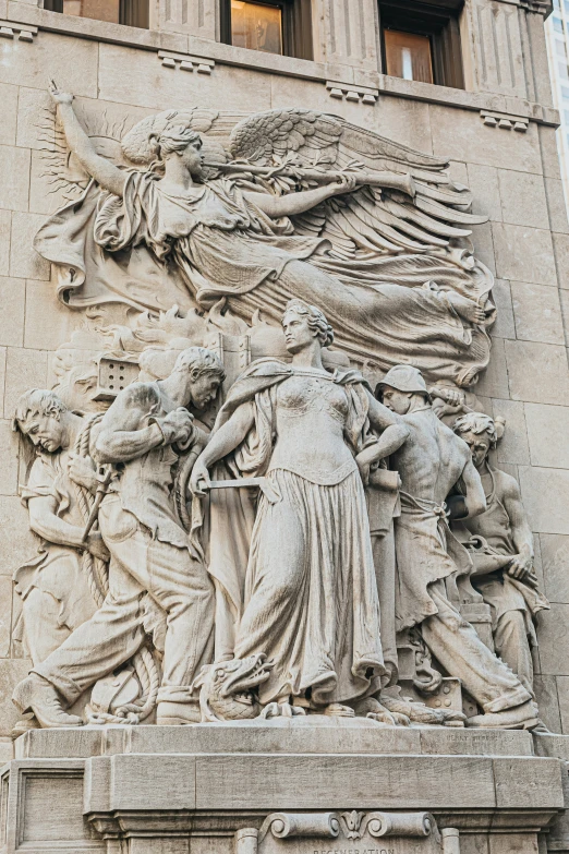 a sculpture of many men holding hands next to a large building