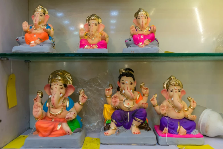 four small statues are displayed in a glass case