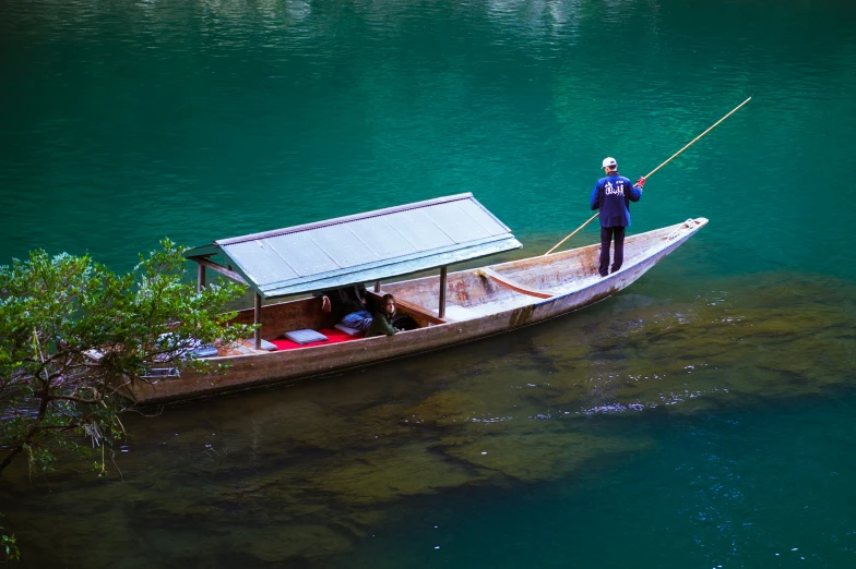 two men stand on the back of a boat