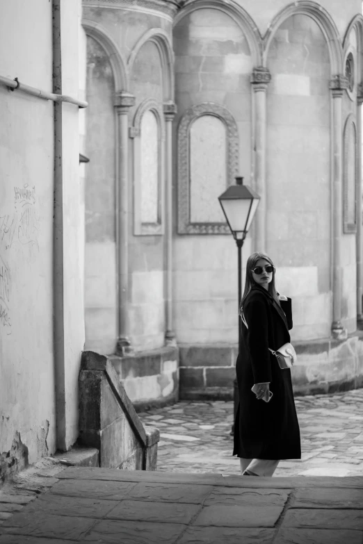 a woman is walking in front of an old building