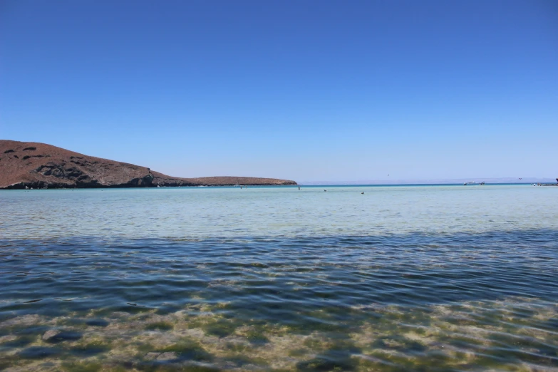 a body of water with some hills in the distance