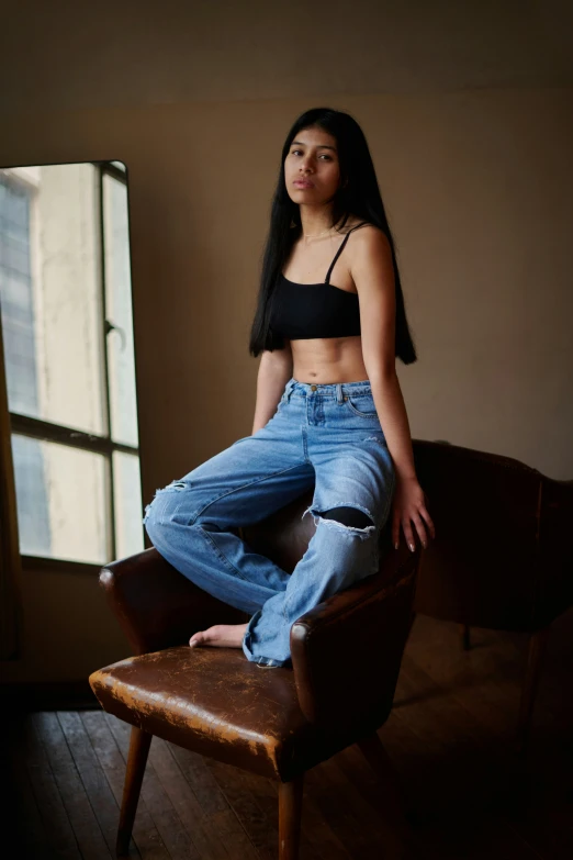 a woman posing on a chair in a black top