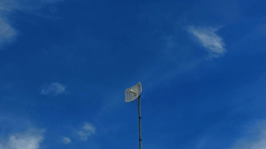 a tall white flag hanging from the side of a tower