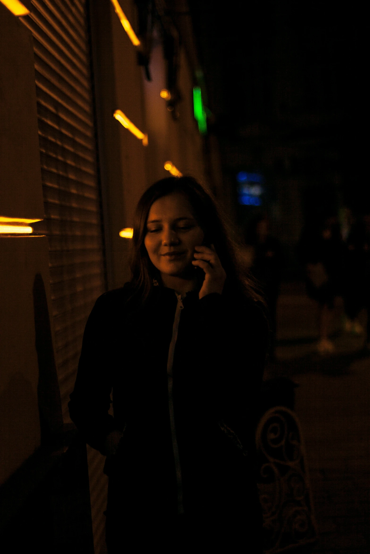 a woman in black talking on a cellphone