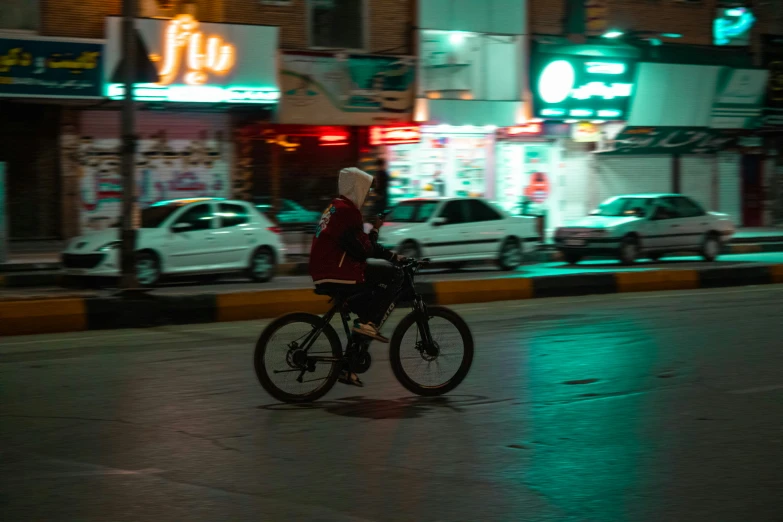 a woman riding a bicycle down the street in the rain