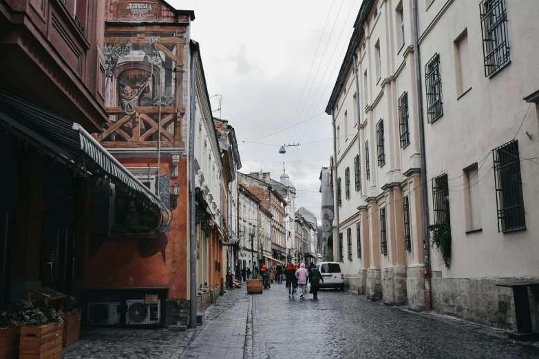 people are walking on a city street surrounded by buildings