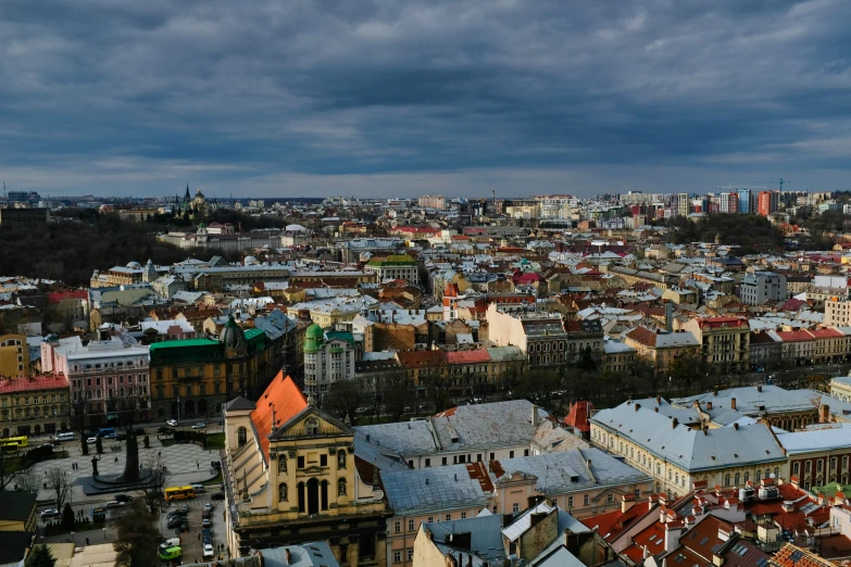 an aerial view shows roofs and buildings with clouds in the sky