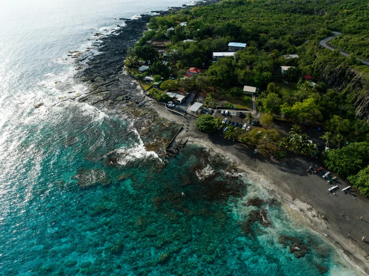 an aerial view of the coast with green trees and people on a boat