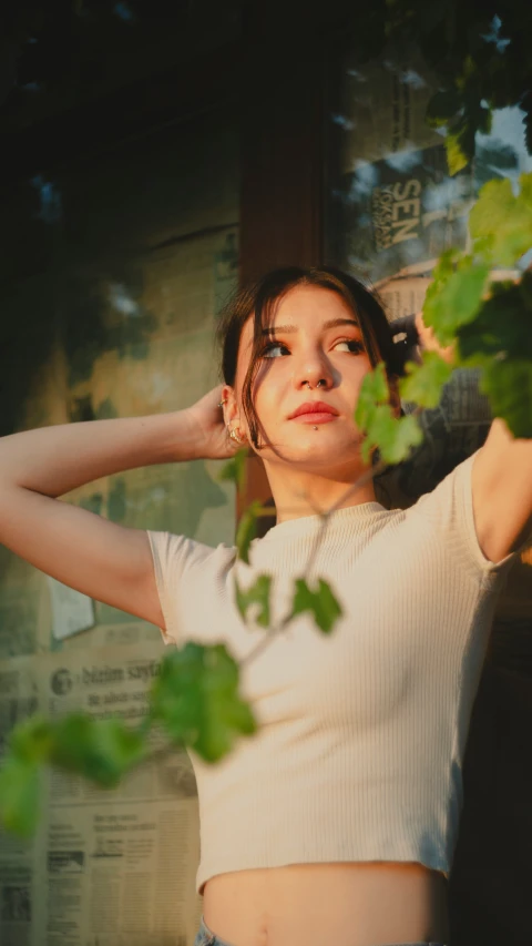 a young lady poses while leaning against a nch