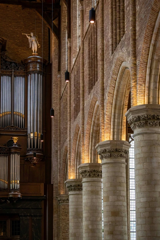 an organ in the foreground with pillars and windows