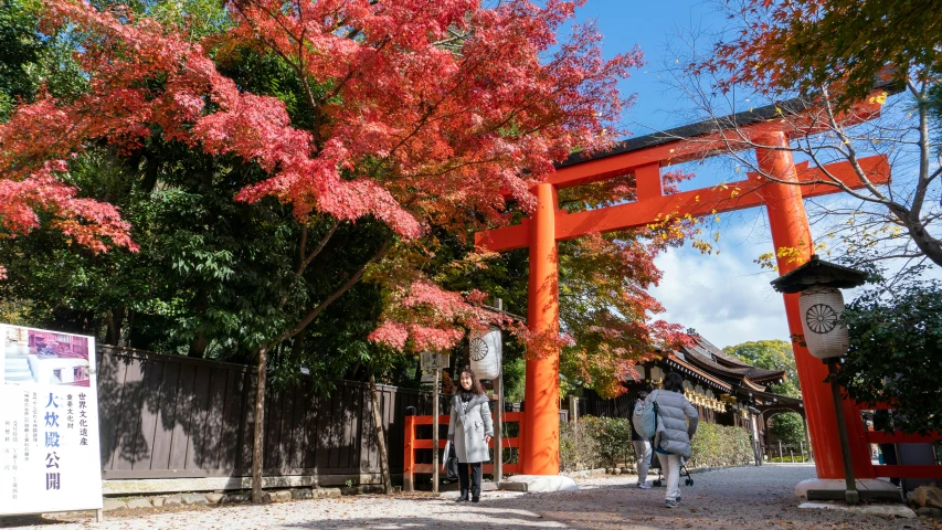 there is a person walking away from an orange gate