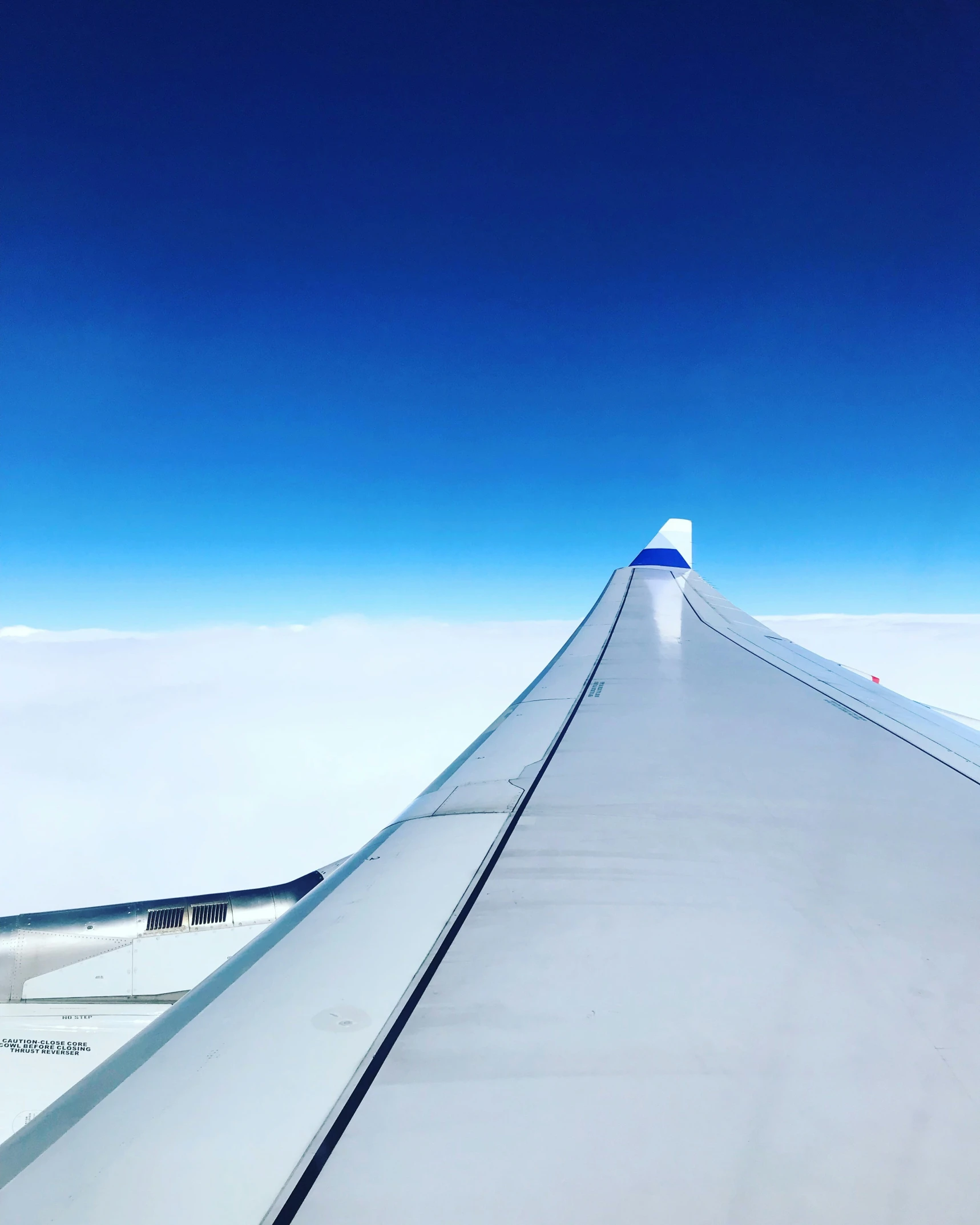 a sky view from inside an airplane with a wing