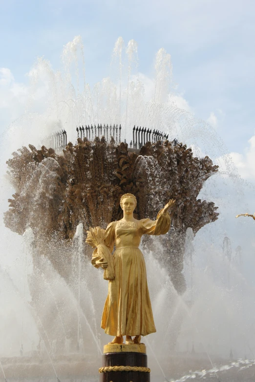 an outdoor fountain featuring a statue with water spouts out of the fountain