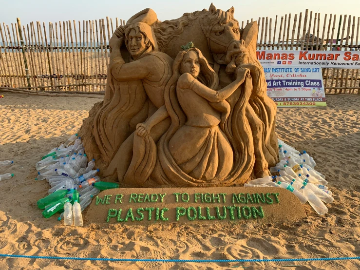a sand sculpture depicting two women and a man