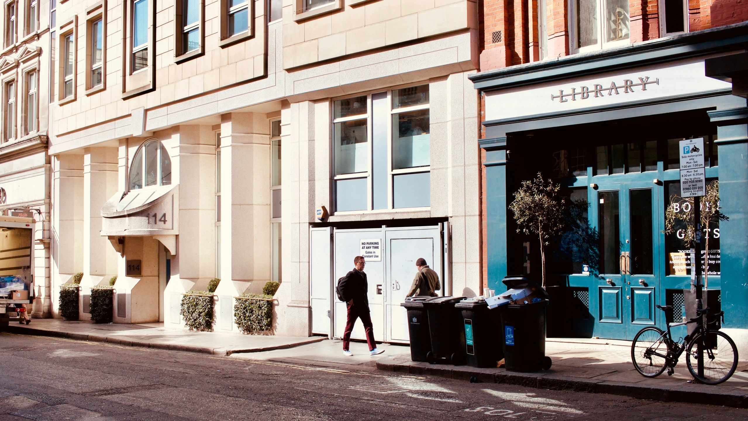 a man stands outside of a two story building