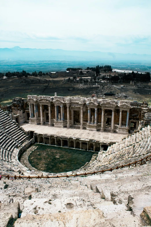 the roman theatre is in ruins with water on the side