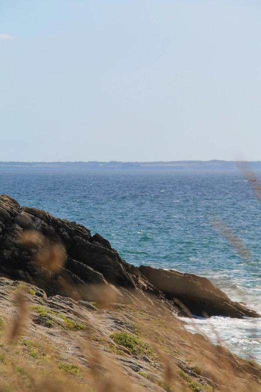 a group of people on the edge of a cliff watching an ocean