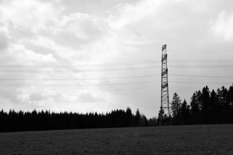 black and white po of power lines against a cloudy sky